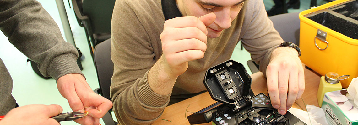Na zdjęciu młody mężczyzna naprawiająy urządzenie. (Fot. Archiwum UMWW)