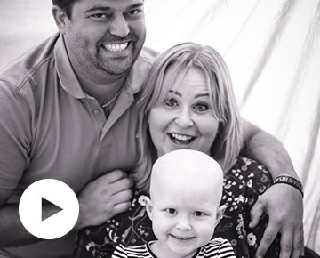Czarno-biała fotografia przedstawia rodziców z dzieckiem chorującym na nowotwór. Zdjęcie pochodzi z archiwum beneficjenta.
