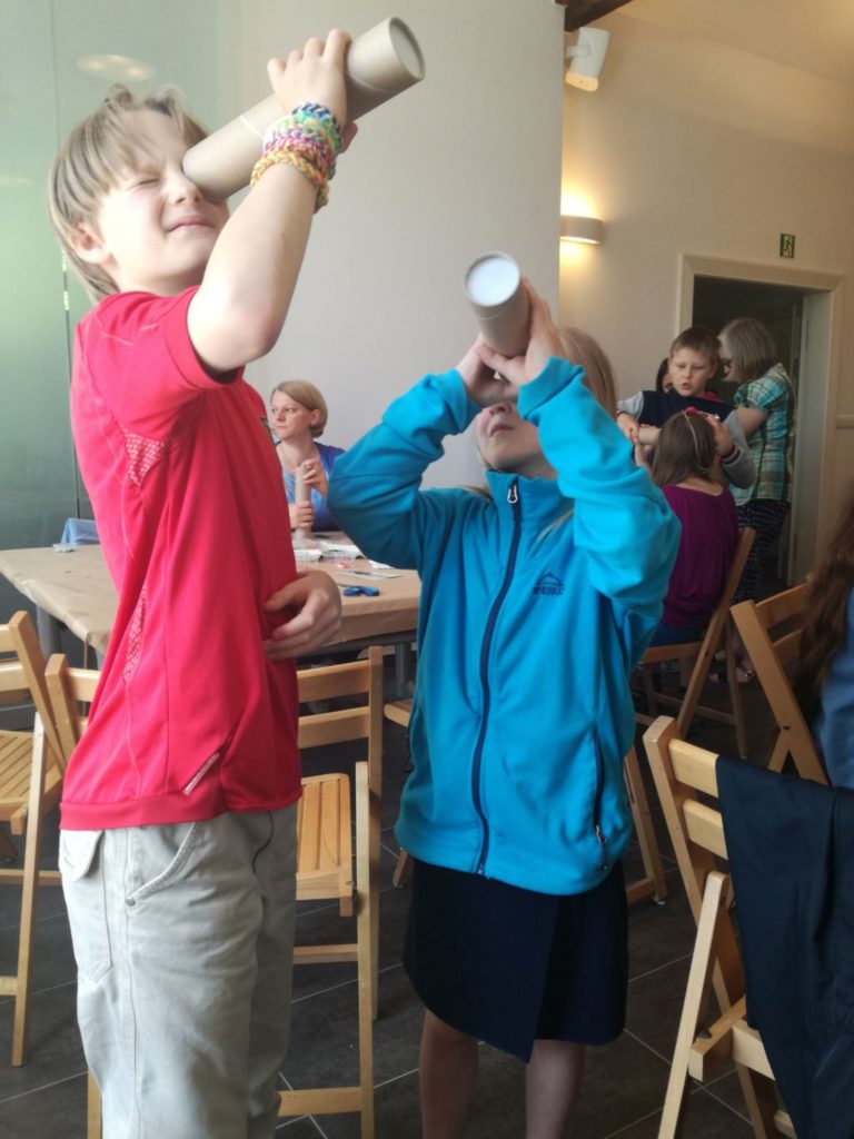 Dziewczynka i chłopiec przeglądają samodzielnie zrobione kalejdoskopy