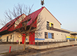 Fotografia przedstawia budynek Gminnego Ośrodka Kultury w Przygodzicach, z odnowioną elewacją. Widać między innymi bramy garaży Ochotniczej Straży Pożarnej, która ma tutaj swoją siedzibe. Autorem zdjęcia jest Robert Kaczmarek.