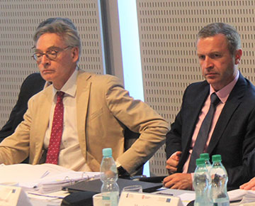 Na zdjęciu: Przy stole konferencyjnym debatuje trzech mężczyzn