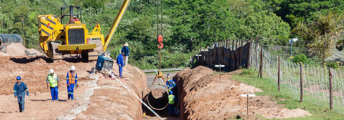 Na zdjęciu przedstawieni są robotnicy wykorzystujący ciężki sprzęt do budowy kanalizacji. Zdjęcie pochodzi z obrazów licencjonowanych przez Depositphotos.com Drukarnie Chroma.