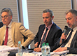 Na zdjęciu przy stole konferencyjnym debatuje trzech mężczyzn.