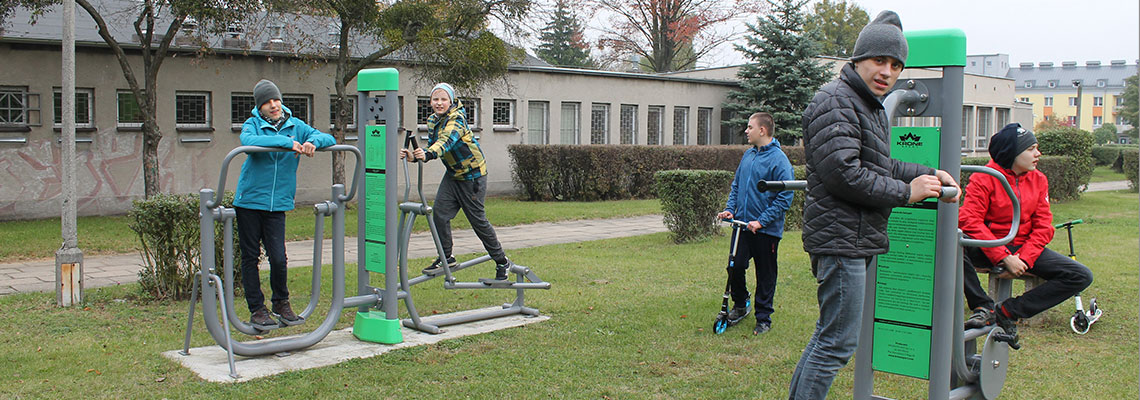 Fotografia przedstawia dzieci korzystające z urządzeń siłowni na świeżym powietrzu. Zdjęcie pochodzi z archiwum beneficjenta.