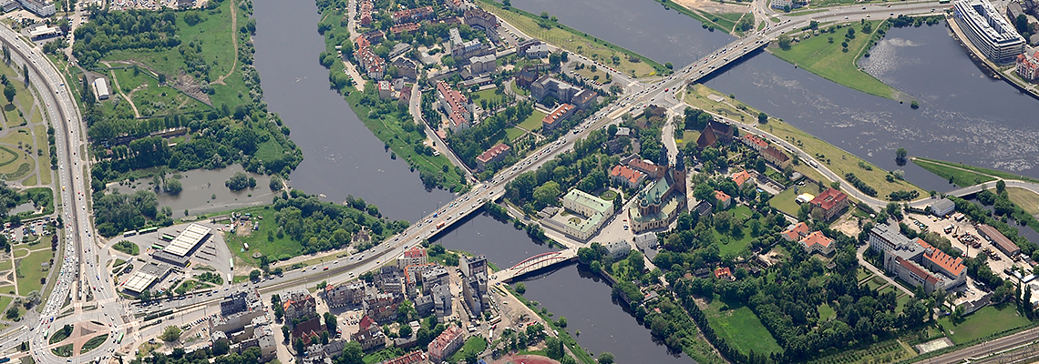 Fotografia przedstawia centrum Poznania z rzeką Wartą, z lotu ptaka. Zdjęcie pochodzi z zasobów portalu fotoportal.poznan.pl.