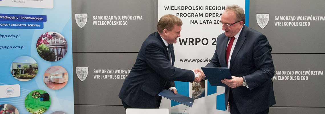 Fotografia przedstawia mężczyzn ściskających dłonie po podpisaniu umowy. Autorem zdjęcia jest Jarosław Tomaszewski.
