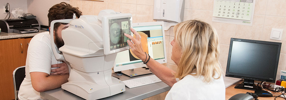Fotografia przedstawia mężczyznę, który przechodzi badanie oka za pomocą specjalistycznej aparatury obsługiwanej przez pielęgniarkę. Autorem zdjęcia jest Jarosław Tomaszewski.