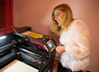 Fotografia przedstawia kobietę w okularach, obsługującą drukarkę laserową. Autorem zdjęcia jest Maciej Motylewski.