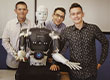 Fotografia przedstawia trzech uśmiechniętych chłopców pozujących do zdjęcia z robotem. Fotografia pochodzi z archiwum beneficjenta.