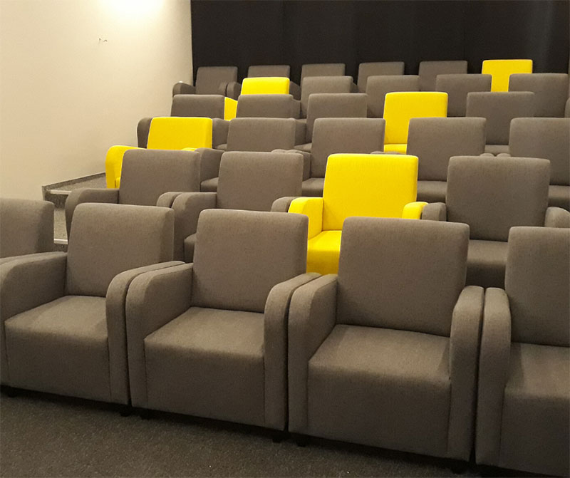Fotografia przedstawia salę w kinie „Lemoniada”. Widocznych jest kilkadziesiąt foteli, większość z nich jest szara, a pięć – żółta. Zdjęcie pochodzi z archiwum beneficjenta.