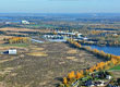 Fotografia przedstawia ogromną połać terenu z lotu ptaka. Widoczne są zabudowania, lasy oraz drogi. Zdjęcie pochodzi z archiwum  Urzędu Miejskiego w Koninie.