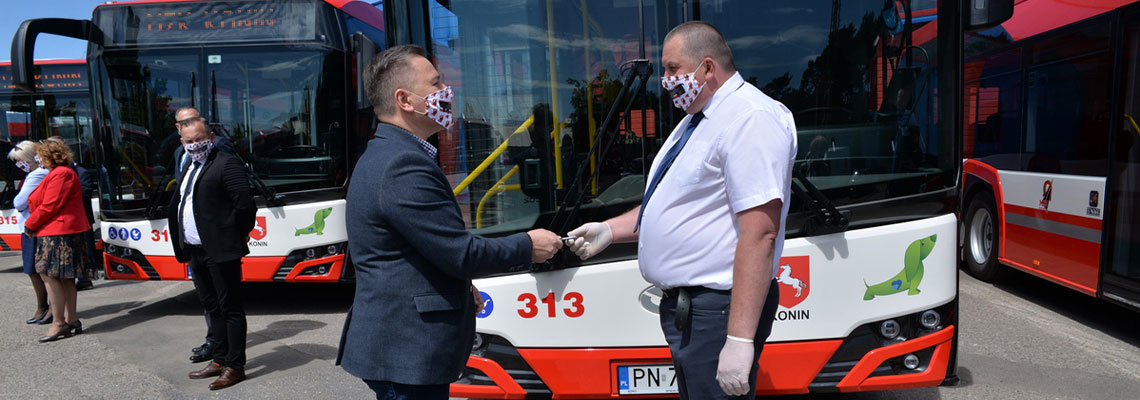 Fotografia przedstawia dwóch mężczyzn na tle nowego autobusu. Mężczyzna w garniturze przekazuje kluczyki drugiemu – prawdopodobnie kierowcy. Zdjęcie pochodzi z archiwum beneficjenta.