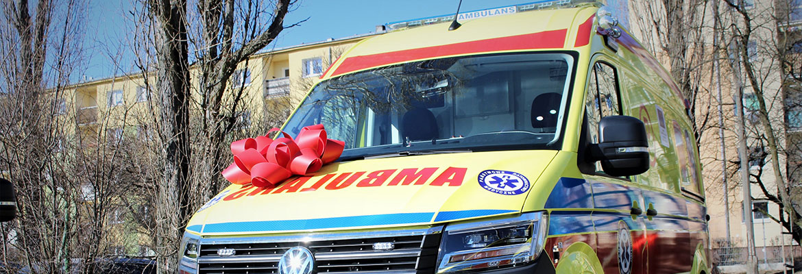 Fotografia przedstawia nowy ambulans, w przeważającej części żółty. Na masce zatknięto czerwoną kokardę. Zdjęcie pochodzi z archiwum Urzędu Marszałkowskiego Województwa Wielkopolskiego.