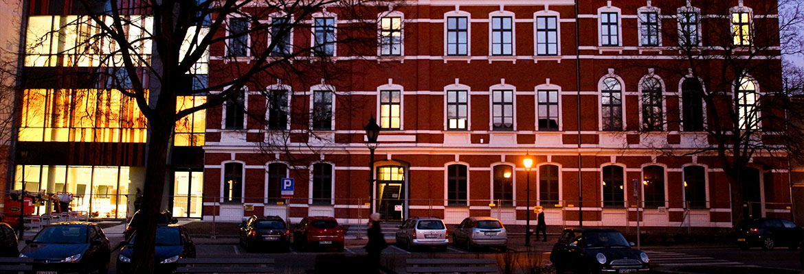 Fotografia przedstawia odnowiony budynek z elewacją z czerwonej cegły oraz dobudowaną częścią, składającą się głównie ze szkła. Autorem zdjęcia jest Andrzej Przewozny.