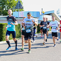 Fotografia przedstawia kilku biegaczy startujących w zawodach, na trasie. Zdjęcie pochodzi z archiwum Urzędu Marszałkowskiego Województwa Wielkopolskiego.