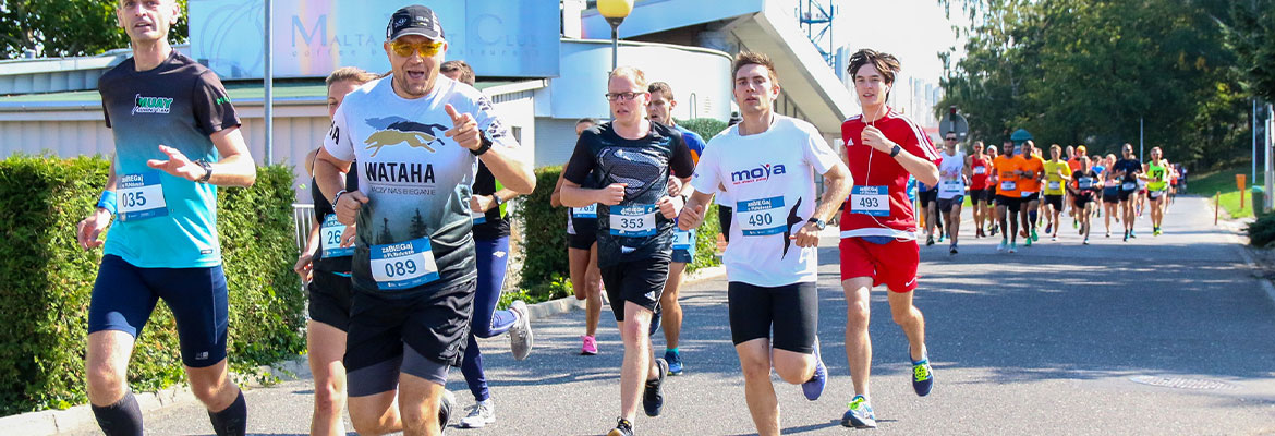 Fotografia przedstawia kilku biegaczy startujących w zawodach, na trasie. Zdjęcie pochodzi z archiwum Urzędu Marszałkowskiego Województwa Wielkopolskiego.