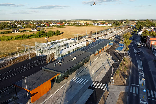 Zdjęcie z lotu ptaka przedstawia dworzec kolejowy. Widoczna jest hala dworca, trzy perony, a także parking i droga dojazdowa. Zdjęcie pochodzi z archiwum beneficjenta.