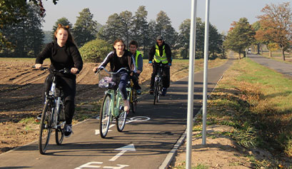 Na zdjęciu widać czwórkę rowerzystów, którzy poruszają się po dedykowanej dla nich ścieżce. Fotografia pochodzi z archiwum beneficjenta.