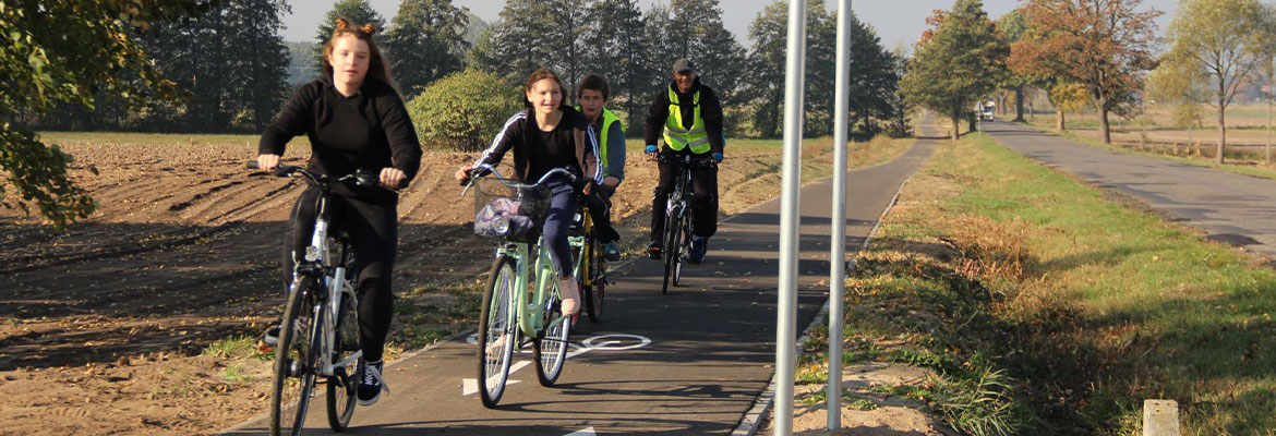 Na zdjęciu widać czwórkę rowerzystów, którzy poruszają się po dedykowanej dla nich ścieżce. Fotografia pochodzi z archiwum beneficjenta.