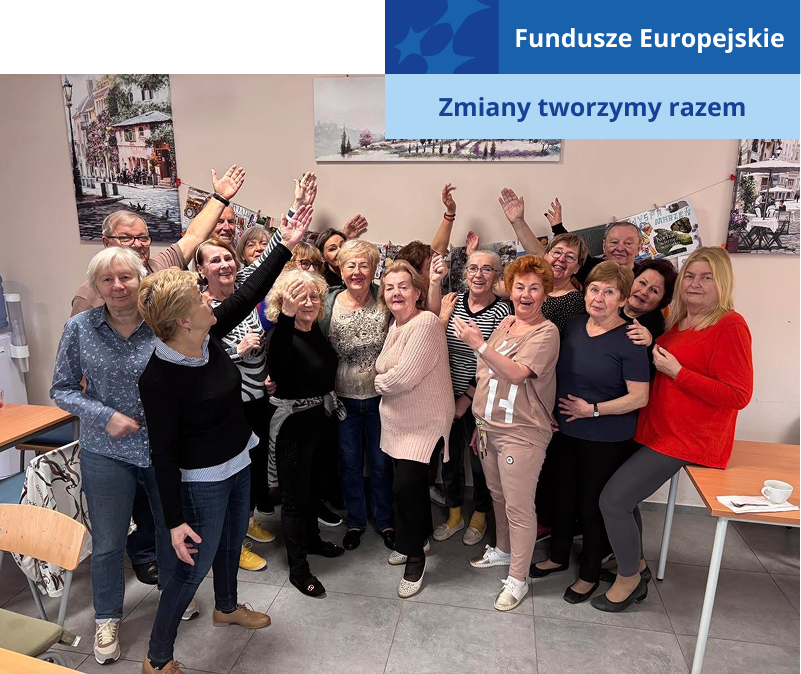 Na zdjęciu widoczna jest grupa seniorów, która stoi przy stworzonym przez siebie obrazie. Każdy z nich z dumą wskazuje ręką na wiszący obraz. Fotografia pochodzi z archiwum beneficjenta.