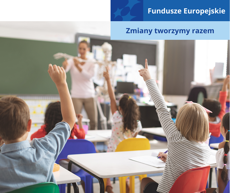 Scena przedstawia sytuację w klasie. Na dalszym planie widoczna jest nauczycielka, która prezentuje dzieciom model. Uczniowie siedzą zaś w ławkach i podnoszą ręce, zgłaszając się do odpowiedzi. Zdjęcie pochodzi z adobe stock.